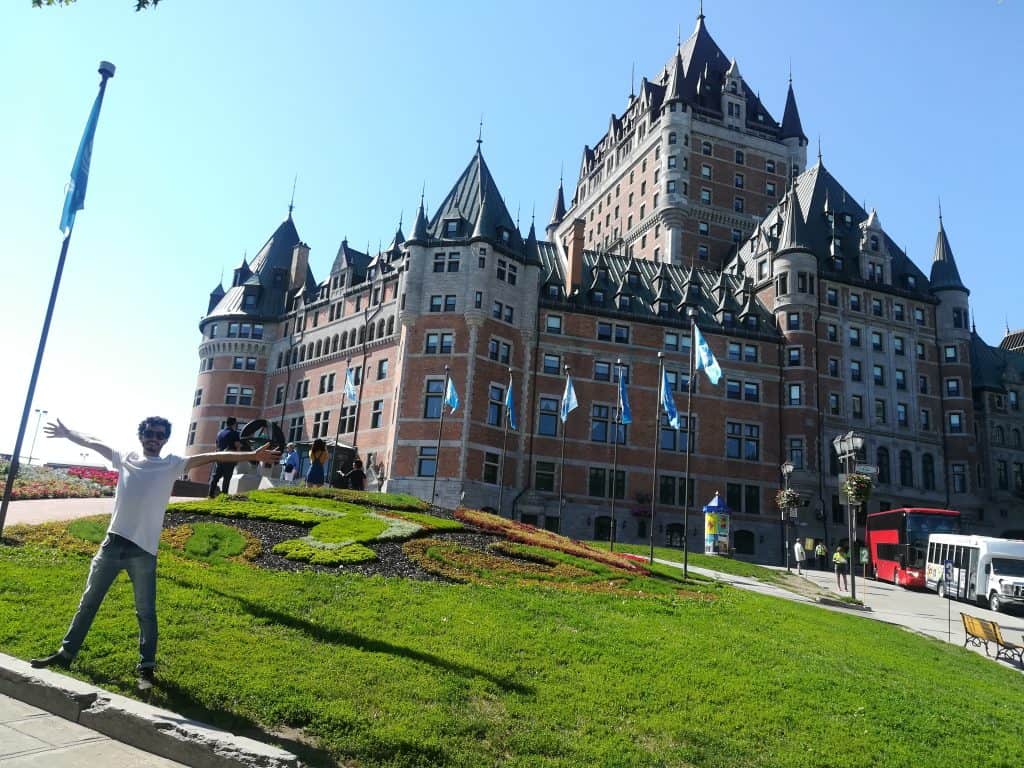 Pedro ferreira de braços abertos na frente do palácio de Quebec durante o Estagio em biotecnologia no Canadá do mitacs globalink 